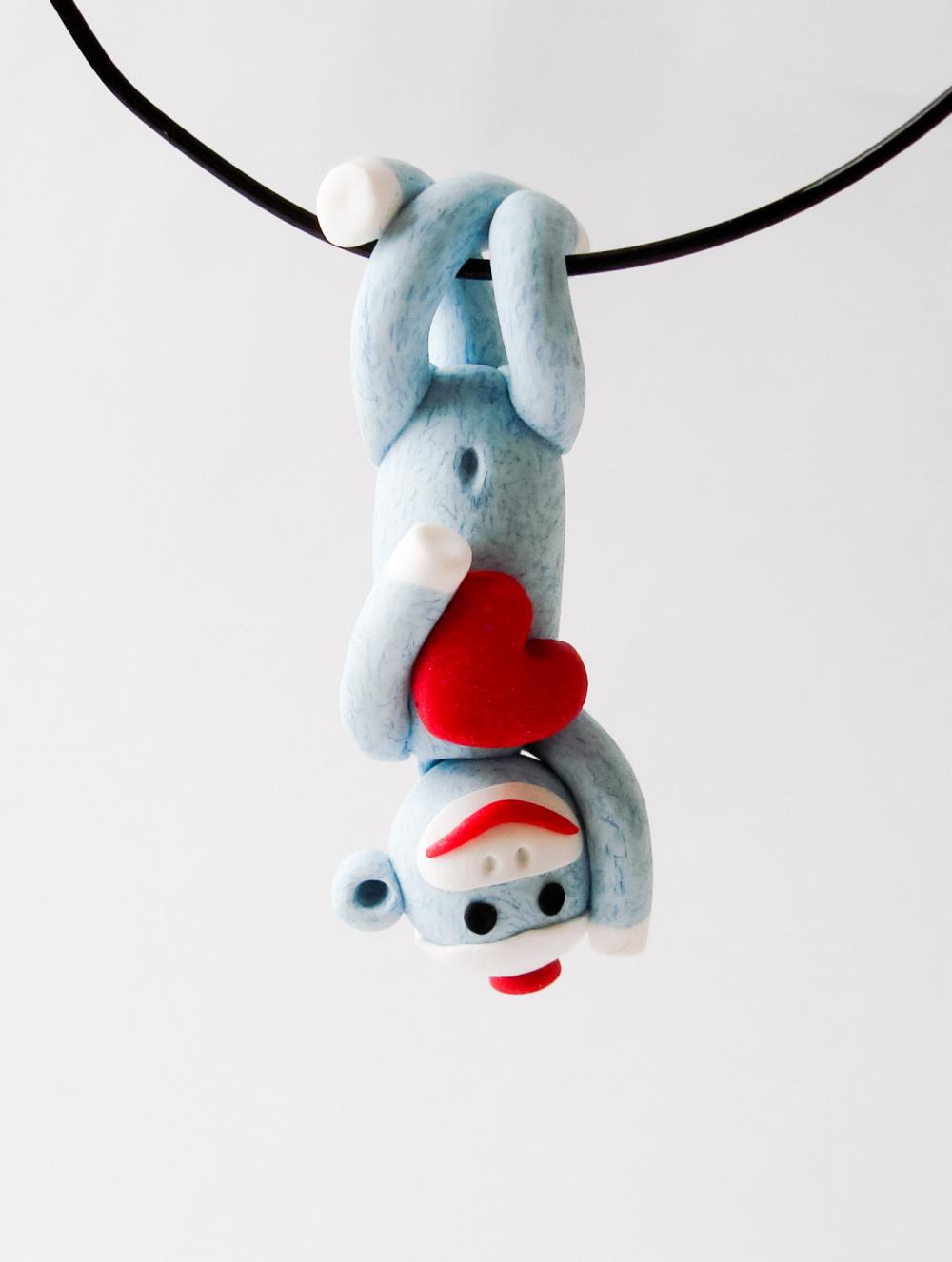 Blue Sock Monkey Pendant Swinging Upside Down Holding A Valentine's Day Heart